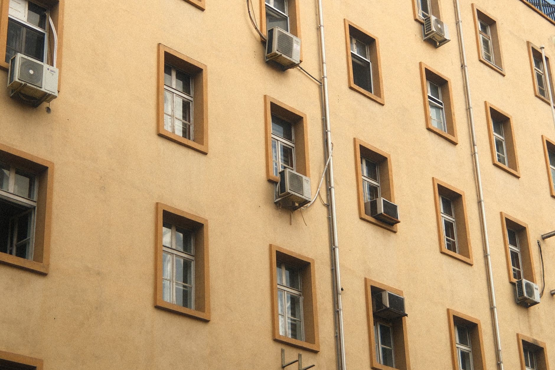 An indoor AC unit on a white wall with water leaking from it.