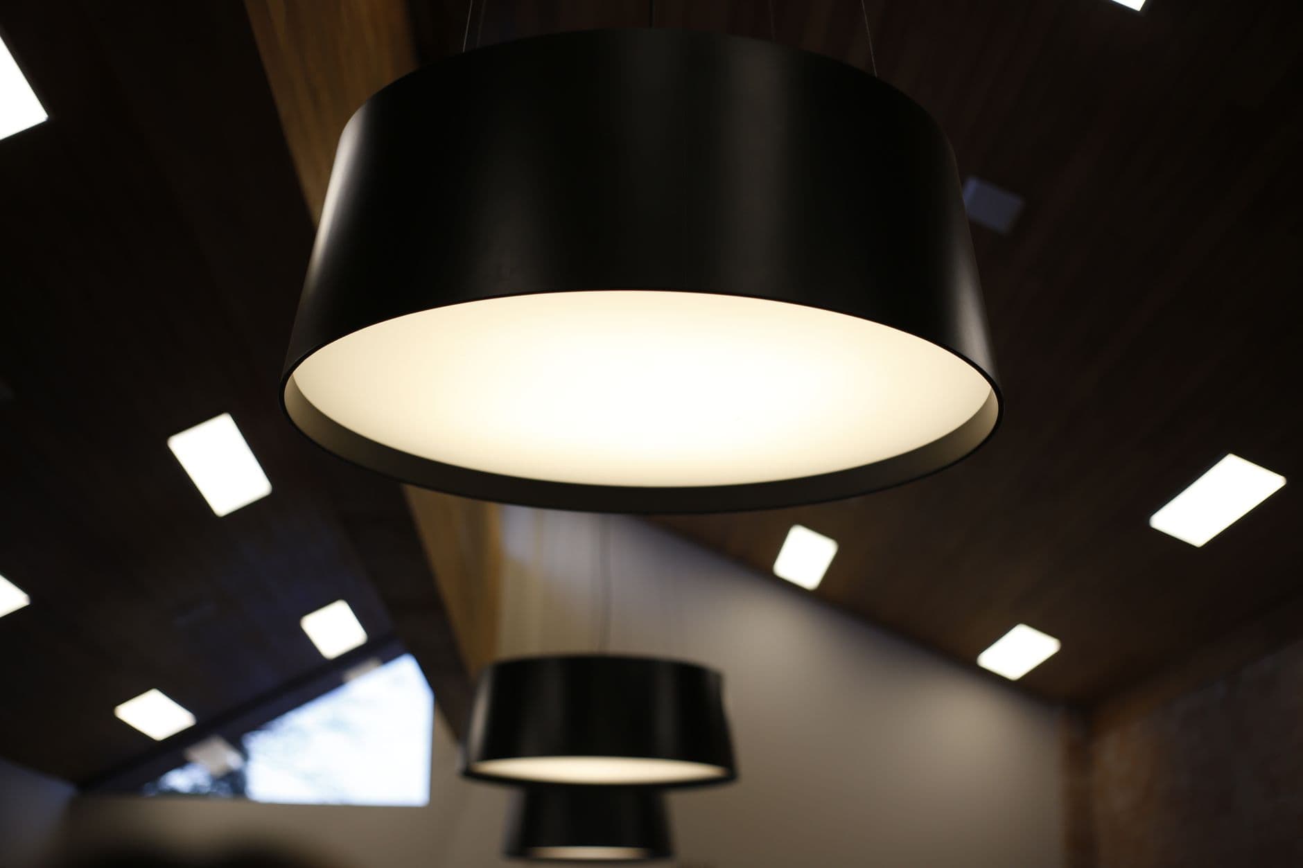 An electrician working on a ceiling lighting system and performing diagnostics in a modern apartment interior.